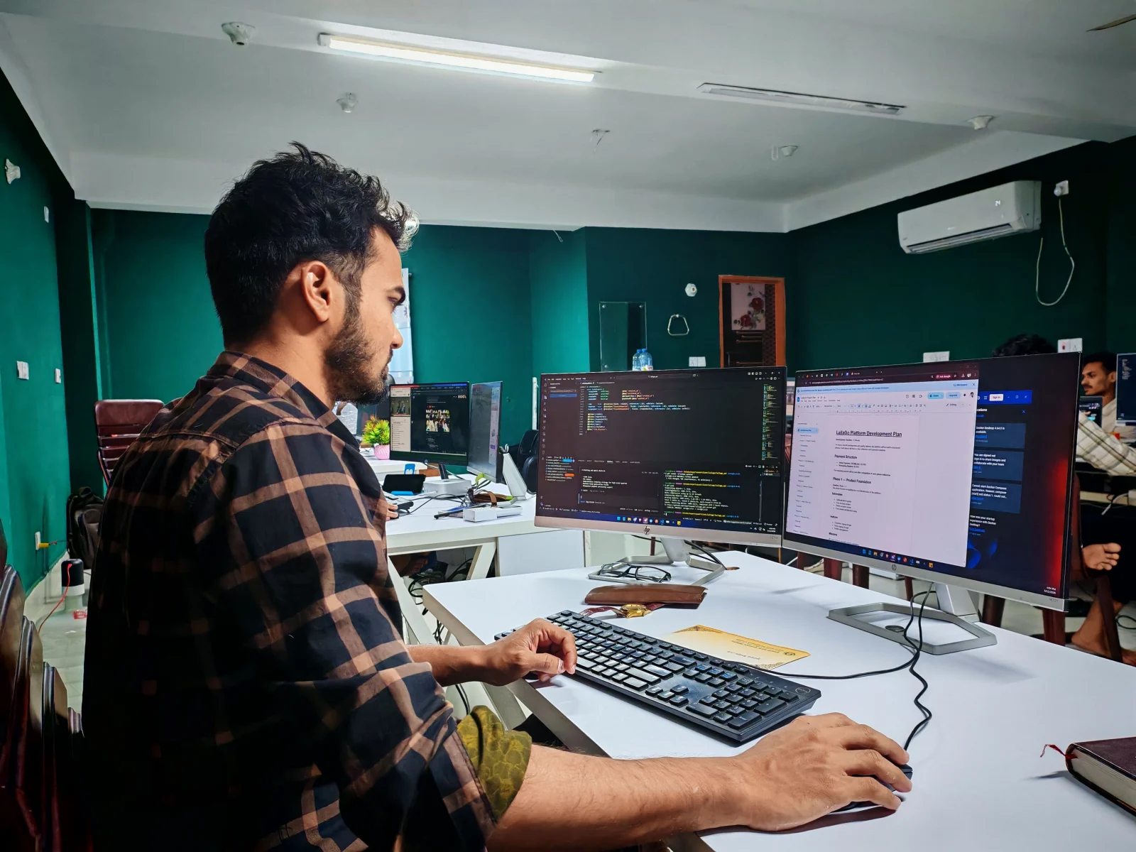 A person working at a desk with two monitors